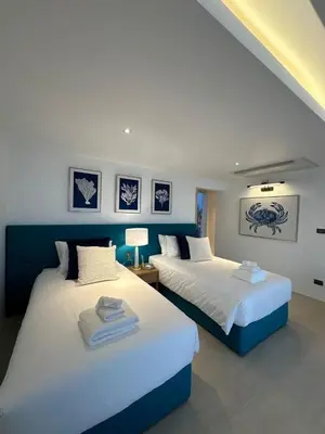 two beds in a room with blue and white at The bay Cape Yamu Villa 2 in Ko Lek