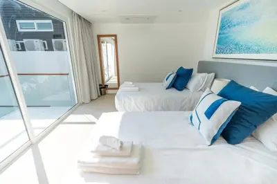a bedroom with two beds with blue and white pillows at The bay Cape Yamu Villa 2 in Ko Lek