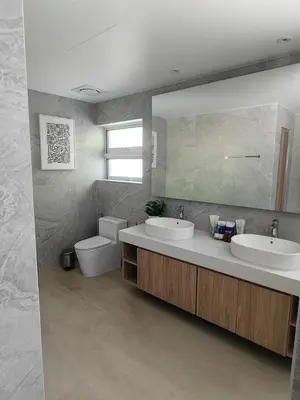 a bathroom with two sinks and a toilet and a mirror at The bay Cape Yamu Villa 2 in Ko Lek