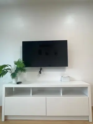 a white entertainment center with a tv on a white wall at Hill Bay Suites Hotel in Patong Beach
