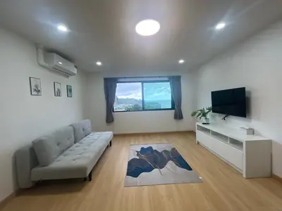 a living room with a couch and a flat screen tv at Hill Bay Suites Hotel in Patong Beach