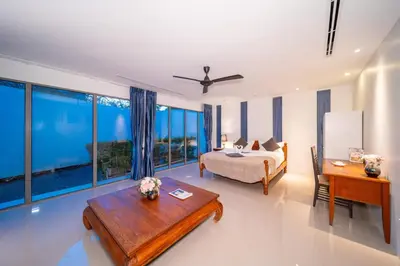 a bedroom with a bed and a table and some windows at Bang Tao 6-bedroom large private pool modern Balinese style leisure holiday villa BBQ family group the park in Bang Tao Beach