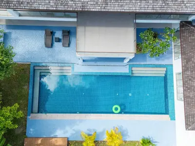 an overhead view of a blue swimming pool at Bang Tao 6-bedroom large private pool modern Balinese style leisure holiday villa BBQ family group the park in Bang Tao Beach