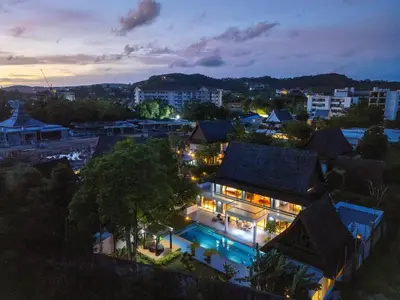 a house with lights on in a city at night at Bang Tao 6-bedroom large private pool modern Balinese style leisure holiday villa BBQ family group the park in Bang Tao Beach
