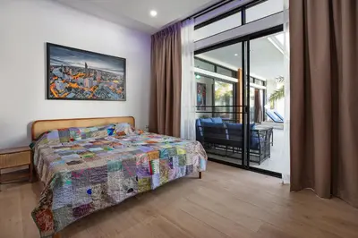 a bedroom with a bed and a large window at Pattana Sun Villa - Modern 4 Bedrooms Villa with Pool in Ban Saiyuan (1)