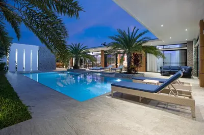 a swimming pool in a house with palm trees at Pattana Sun Villa - Modern 4 Bedrooms Villa with Pool in Ban Saiyuan (1)