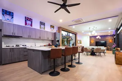 a kitchen with a bar and a dining room at Pattana Sun Villa - Modern 4 Bedrooms Villa with Pool in Ban Saiyuan (1)