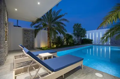 a villa with a swimming pool at night at Pattana Sun Villa - Modern 4 Bedrooms Villa with Pool in Ban Saiyuan (1)
