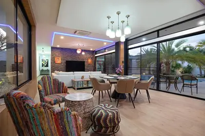 a living room with a couch and a table and chairs at Pattana Sun Villa - Modern 4 Bedrooms Villa with Pool in Ban Saiyuan (1)