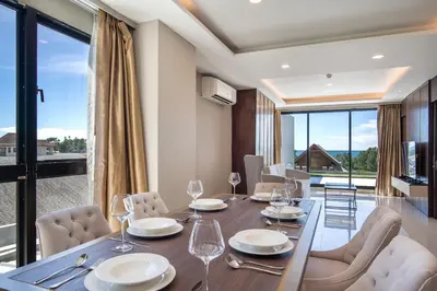 a dining room with a table and chairs and a large window at Surin Beach Serviced 3 Bedroom Sea View Apart-ment Comprehensive Facilities Resort Pool Gym Guest Choice in Surin Beach