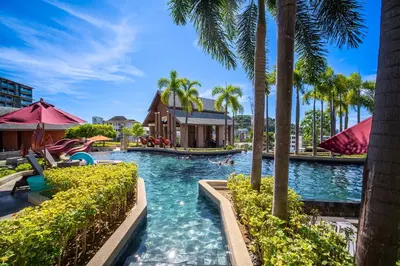 a pool at a resort with palm trees at Surin Beach Serviced 3 Bedroom Sea View Apart-ment Comprehensive Facilities Resort Pool Gym Guest Choice in Surin Beach