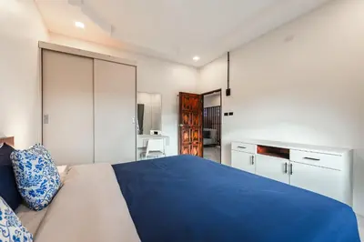 a bedroom with a blue bed and white cabinets at Areca Holiday Villa 3, Naiharn Beach in Rawai Beach