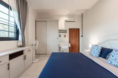 a bedroom with a blue bed and a kitchen at Areca Holiday Villa 3, Naiharn Beach in Rawai Beach