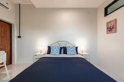 a bedroom with a large blue bed with two tables at Areca Holiday Villa 3, Naiharn Beach in Rawai Beach