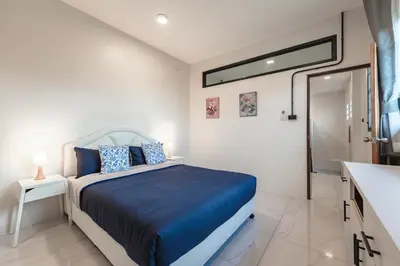 a bedroom with a bed and a sink and a mirror at Areca Holiday Villa 3, Naiharn Beach in Rawai Beach