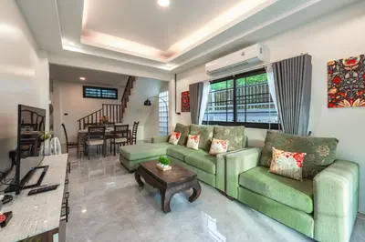 a living room with two green couches and a table at Areca Holiday Villa 3, Naiharn Beach in Rawai Beach