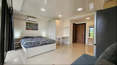 a bedroom with a bed and a table in it at Nature View Residence in Ban Mai Salae