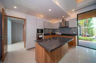 a kitchen with a large island in the middle at BangTao Anchan \u8c6a\u534e\u4e24\u5367 \u79c1\u4eba\u6cf3\u6c60 \u73b0\u4ee3\u5ea6\u5047\u5df4\u5398\u98ce in Layan Beach