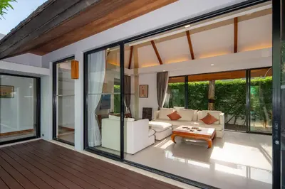 a living room with large windows and a white couch at BangTao Anchan \u8c6a\u534e\u4e24\u5367 \u79c1\u4eba\u6cf3\u6c60 \u73b0\u4ee3\u5ea6\u5047\u5df4\u5398\u98ce in Layan Beach