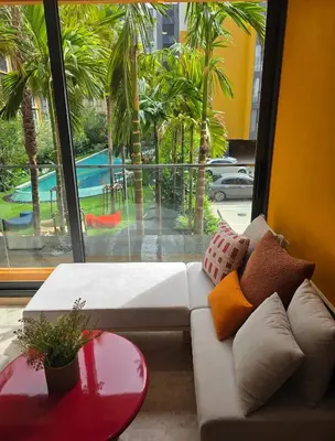 a living room with a couch and a table and a window at The Base Rise in Phuket Town