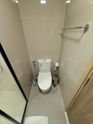 a small bathroom with a toilet and a shower at The Base Rise in Phuket Town