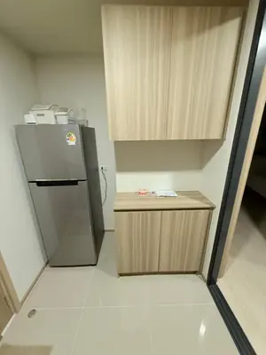 a kitchen with a refrigerator and a wooden cabinet at The Base Rise in Phuket Town