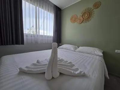 a white bed with a towel on it with a window at Seabreeze Suite 1-Bed T3-637 in Phuket Town