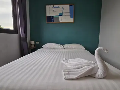 a bed with white sheets and a towel on it at Coastal Comfort 2 Bed T2-617 in Phuket Town