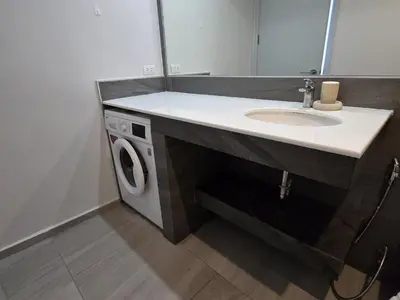 a bathroom with a sink and a washing machine at Coastal Comfort 2 Bed T2-617 in Phuket Town