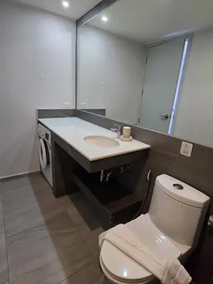 a bathroom with a toilet and a sink and a mirror at Coastal Comfort 2 Bed T2-617 in Phuket Town