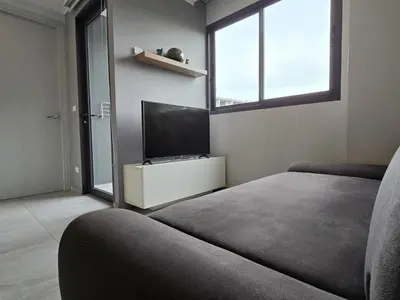 a living room with a couch and a flat screen tv at Coastal Comfort 2 Bed T2-617 in Phuket Town