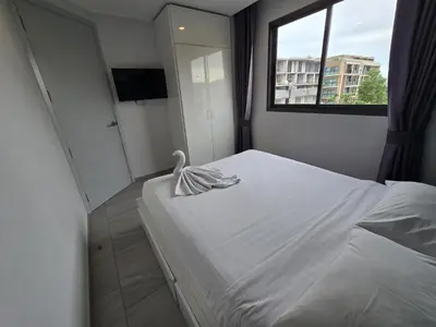 a bedroom with a white bed with a swan on it at Coastal Comfort 2 Bed T2-617 in Phuket Town