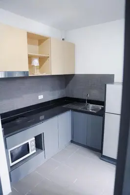 a small kitchen with a sink and a microwave at Beachside Bliss 2- Bed HM612 in Phuket Town