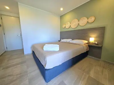 a bedroom with a bed with two wooden plates on the wall at Island Drift Studio T3-332 in Chalong