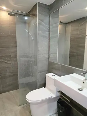 a bathroom with a toilet and a shower and a sink at Lagoon Loft Studio T3-627 in Chalong