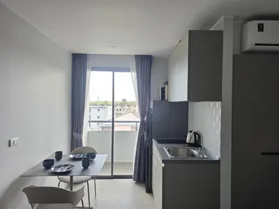 a kitchen with a sink and a table with chairs at Lagoon Loft Studio T3-627 in Chalong