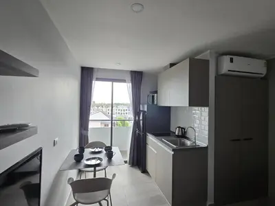 a small kitchen with a sink and a table and chairs at Lagoon Loft Studio T3-627 in Chalong
