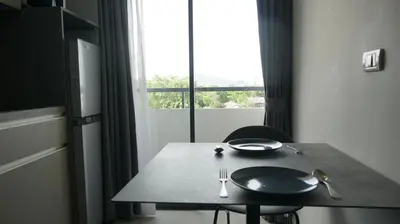 a table with a plate and fork and a window at Palm Bay Studio T3 -532 in Phuket Town