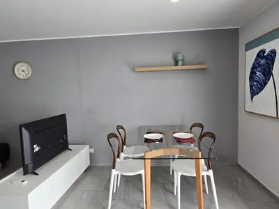 a dining room with a table and chairs and a tv at Skyline Serenity 1Bed T2-721 in Phuket Town