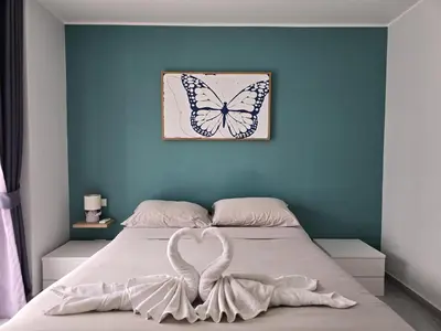 a bedroom with a bed with a butterfly picture on the wall at Skyline Serenity 1Bed T2-721 in Phuket Town