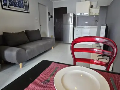 a living room with a table and a red chair at 1 BR Condo in good location NV402 in Phuket Town