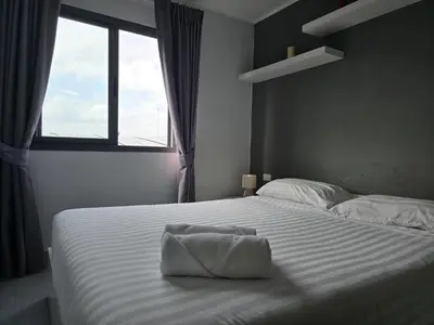 a bedroom with a large white bed with a window at 1 BR Condo in good location NV402 in Phuket Town