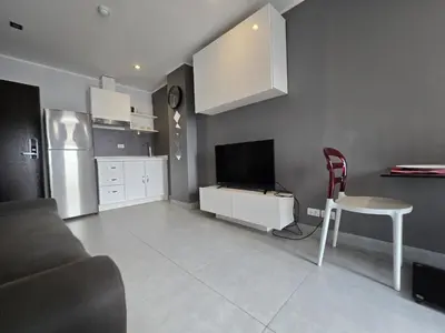 a living room with a couch and a table and a television at 1 BR Condo in good location NV402 in Phuket Town