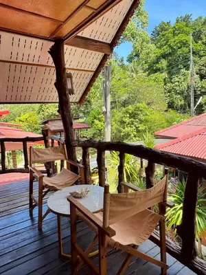 a porch with chairs and a table on a deck at Bangalow Coconut corner in Ban Laem Sai