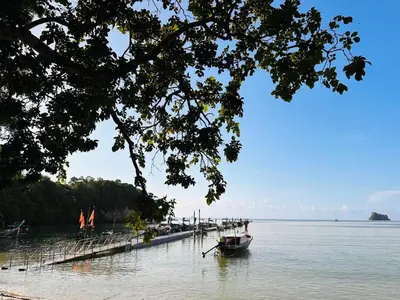a boat is docked at a dock in the water at Bangalow Coconut corner in Ban Laem Sai