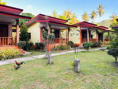 a house with two chickens in front of it at Bangalow Coconut corner in Ban Laem Sai
