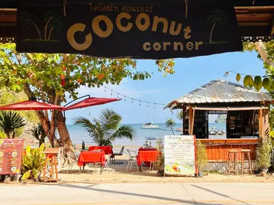 a restaurant on the beach with tables and chairs at Bangalow Coconut corner in Ban Laem Sai