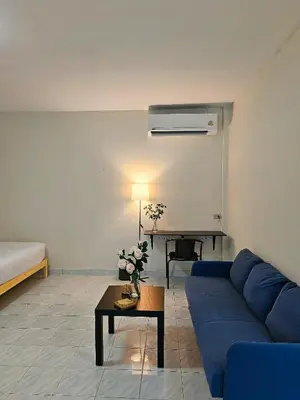 a living room with a blue couch and a table at Friends Retreat - Phuket Airport in Ban Bo Han