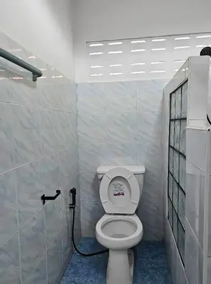 a bathroom with a white toilet in a room at Friends Retreat - Phuket Airport in Ban Bo Han