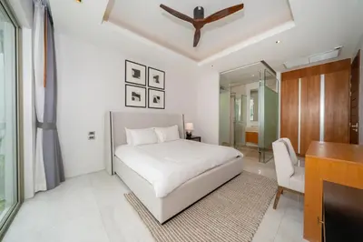 a white bedroom with a bed and a desk at Luxury 4BR Pool Villa Botanica Bangtao Beach in Ban Thalat Choeng Thale